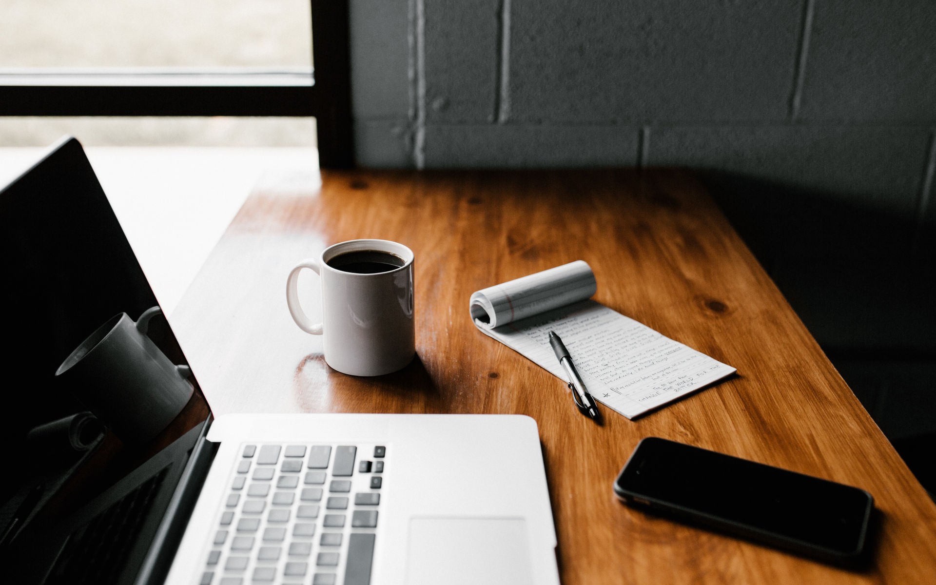 Laptop, notebook and coffee on a desk