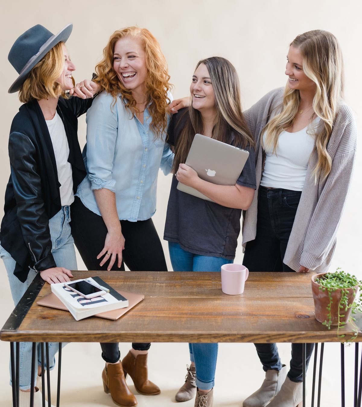 Friends laughing together around a tablet